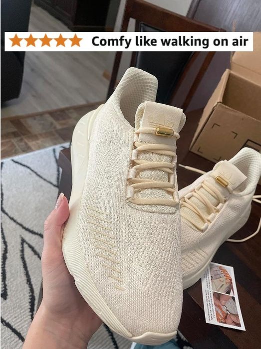 A reviewer holding a beige sneaker with a review visible, reading 