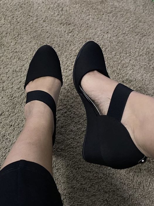 A photo of a reviewer showcasing herself wearing the black pumps.