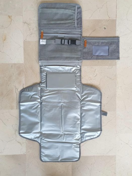 A portable baby changing mat featuring storage pockets and an easy-to-wipe surface, ideal for diaper changes while you're on the move.