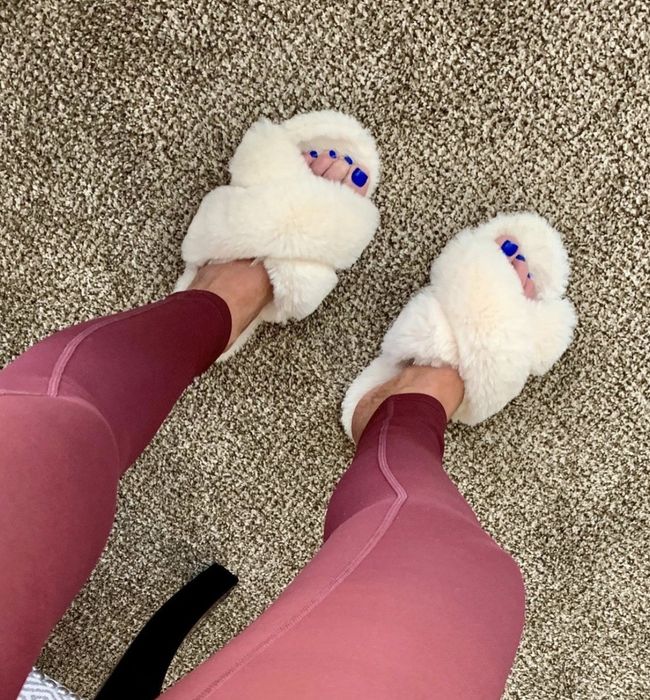 A reviewer showing off their cream slippers.