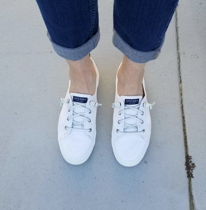 The white Sperry sneakers worn by a reviewer.