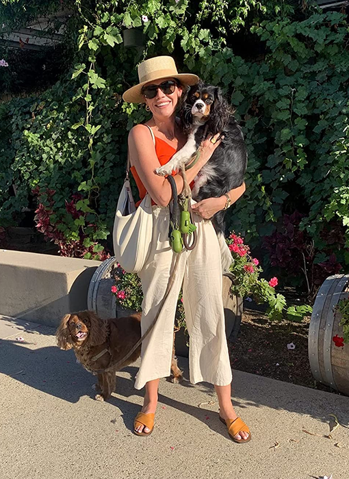 A reviewer showcasing linen pants while holding a dog