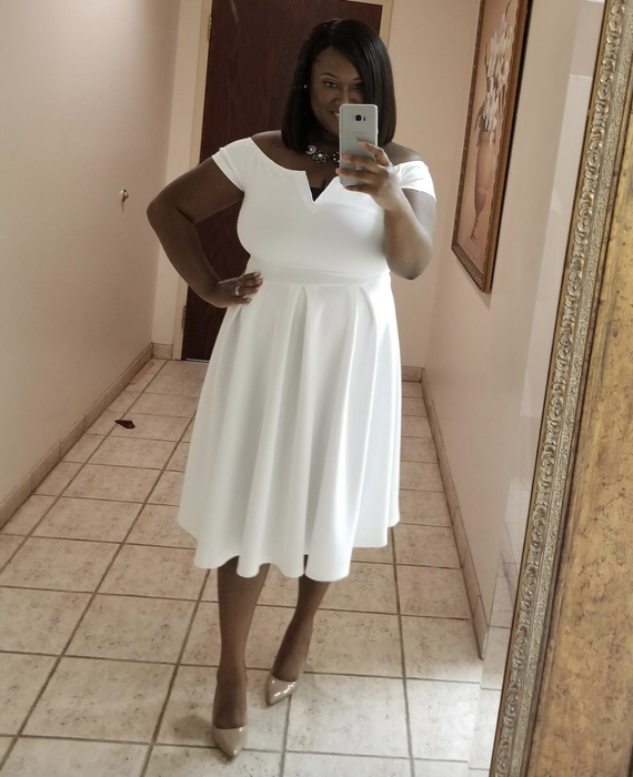 a reviewer wearing the white dress