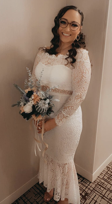 reviewer wearing the dress with a belt