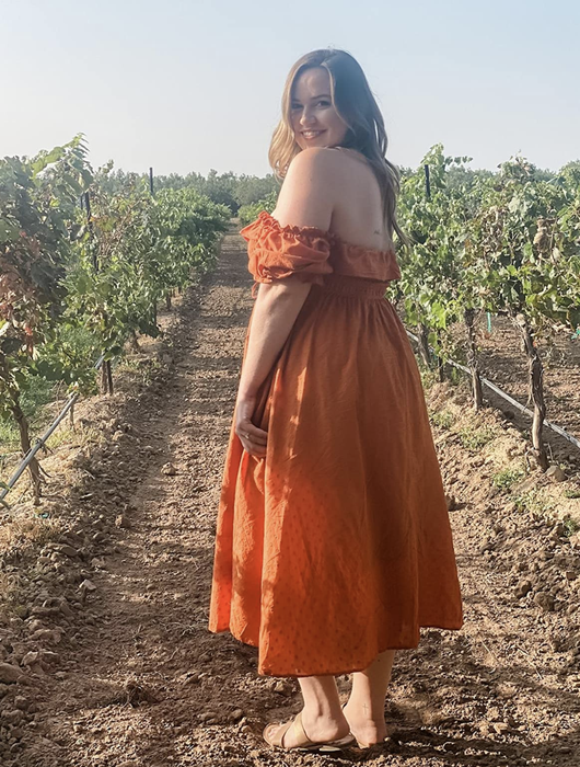 A reviewer wearing an orange dress.