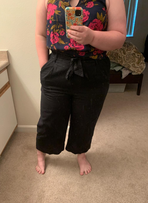 Reviewer taking a mirror selfie in black paperbag pants