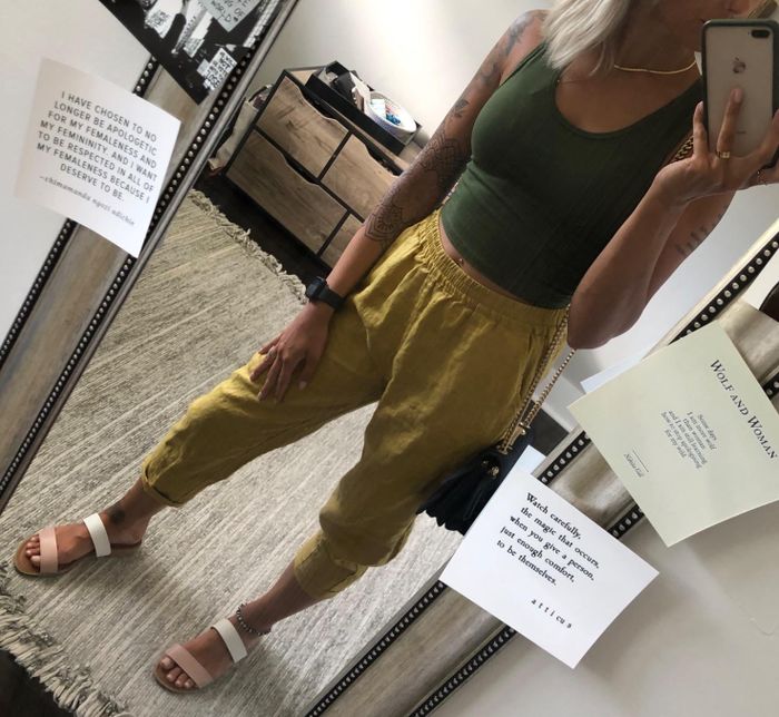 Reviewer taking a mirror selfie in green tapered trousers