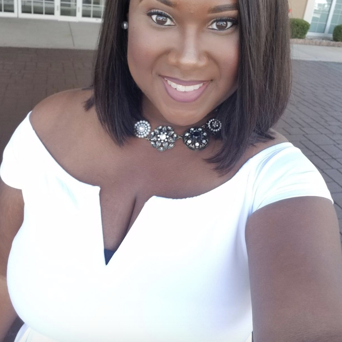 a reviewer accessorizing the dress with a necklace