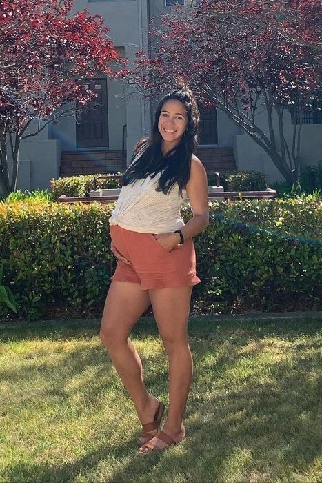 A pregnant reviewer is wearing terra-cotta colored shorts.