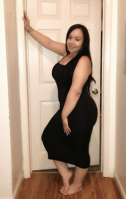 A reviewer showcasing the dress in classic black