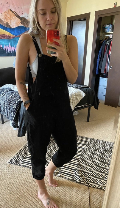 A reviewer models a sleek black jumpsuit.