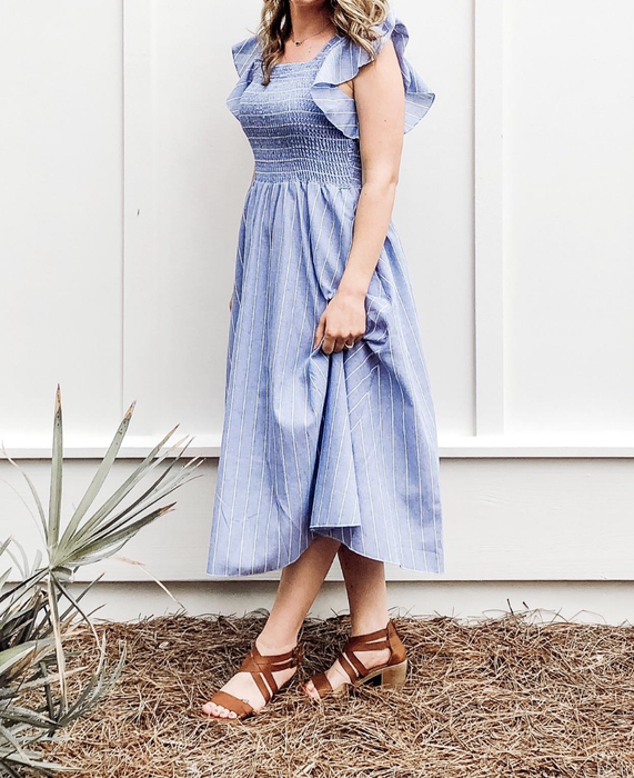 A reviewer is wearing a striped midi dress.