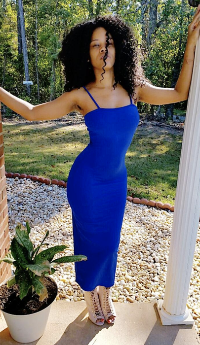 A reviewer in a stunning royal blue bodycon dress