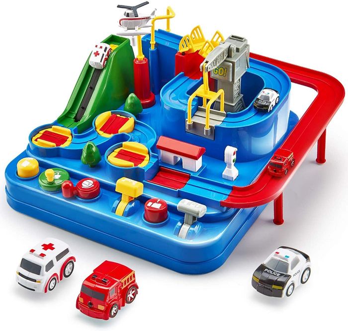 The race track next to an ambulance toy, a fire truck, and a police car.