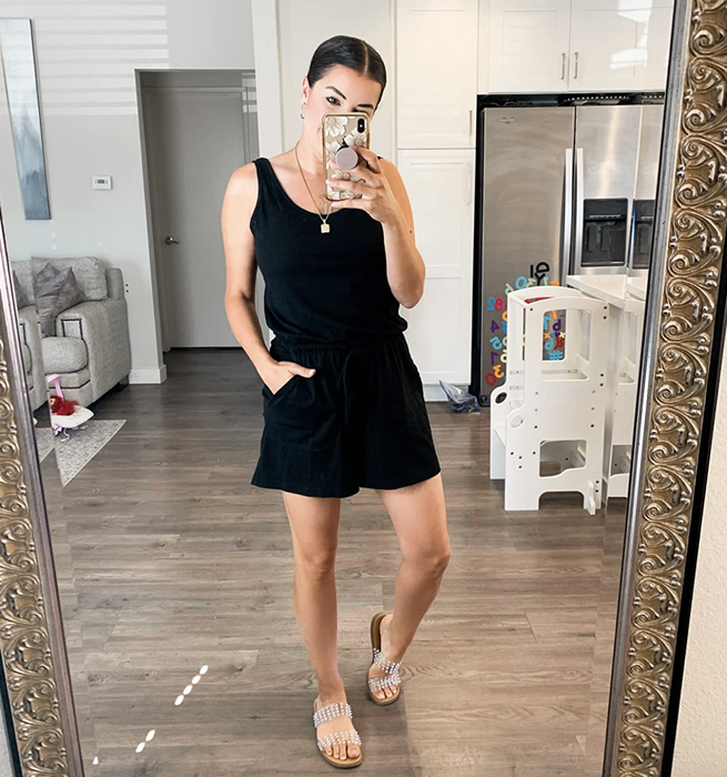 A reviewer is wearing a black romper.