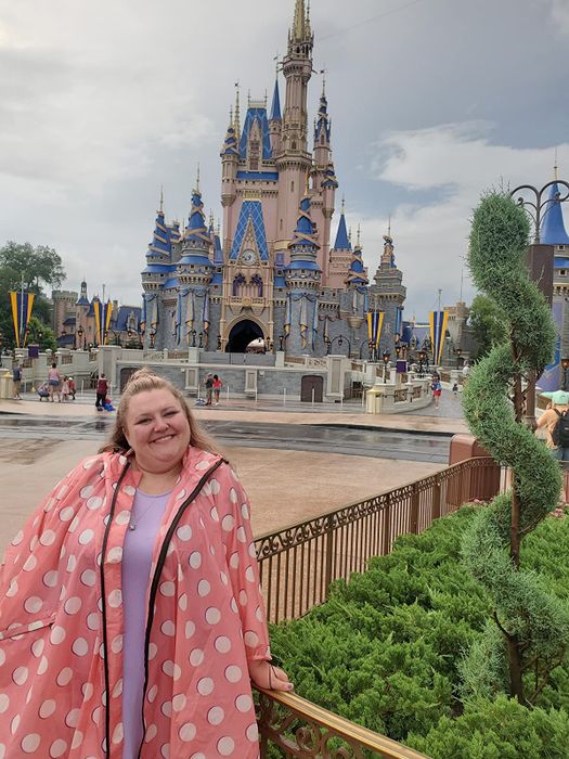 A reviewer rocking a pink polka dot poncho jacket while at Disney.