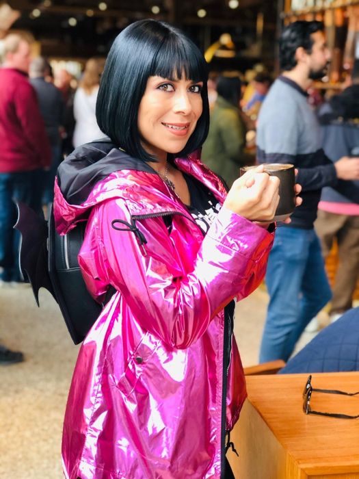 A reviewer sporting a vibrant hot pink metallic raincoat.