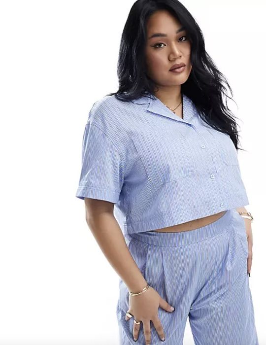 A woman strikes a confident pose in a casual, loose-fitting matching top and pants set, perfect for smart-casual wear.