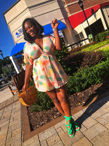 reviewer wearing the dress paired with bright green pumps