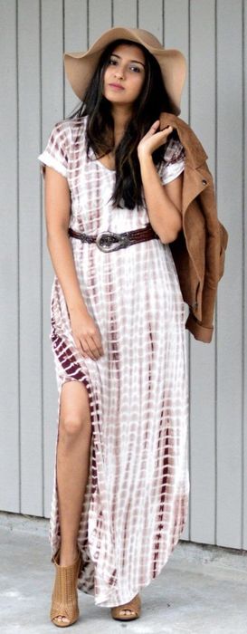 The reviewer is wearing a tie-dye dress with sleeves, slits on both sides, and has accessorized with a belt, hat, booties, and a jacket.