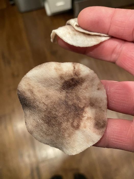 Reviewer holding a used dog ear wipe that has been soiled.