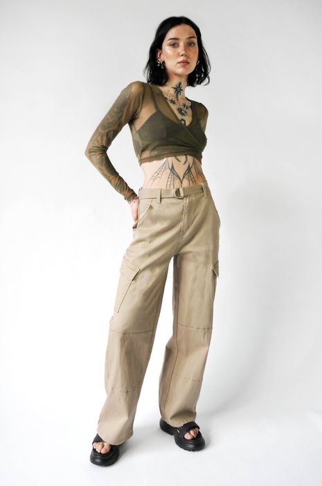 A model is showcasing beige cargo pants paired with a matching belt.