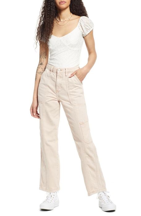 model, lower half, wearing cream-colored cargo jeans