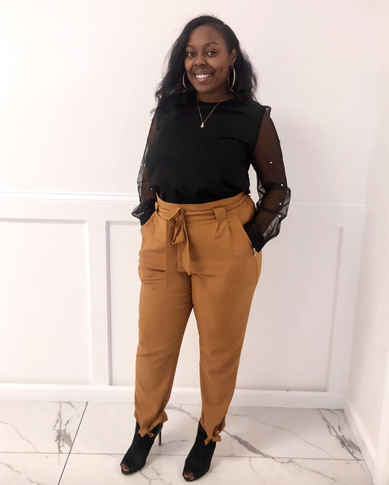A reviewer wearing the yellow high-waisted pants