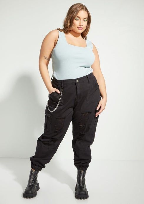 model sporting ripped black cargo joggers with chain detailing