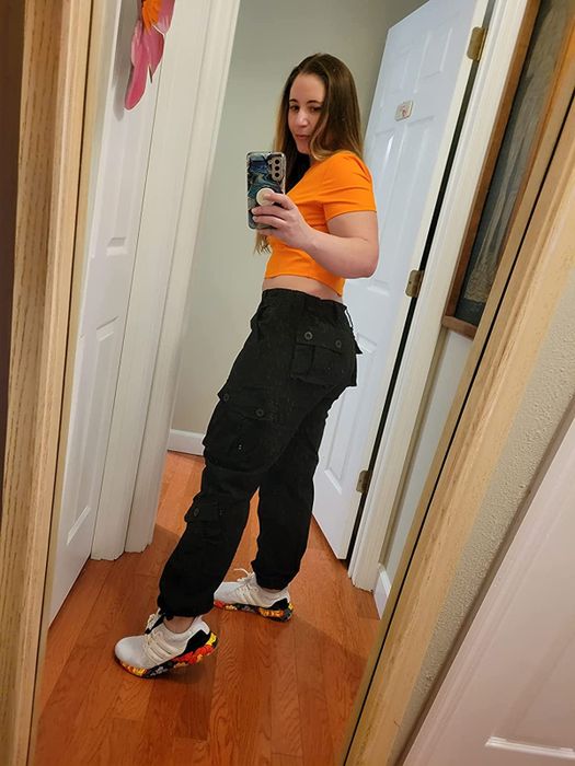 Reviewer’s back view mirror selfie, dressed in black cargo pants.