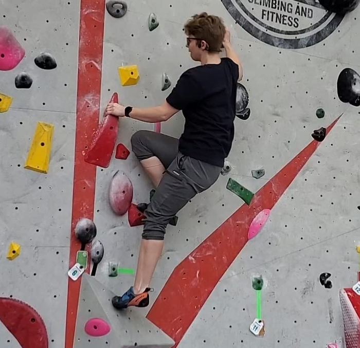 Reviewer photo climbing a rock wall, wearing gray pants.