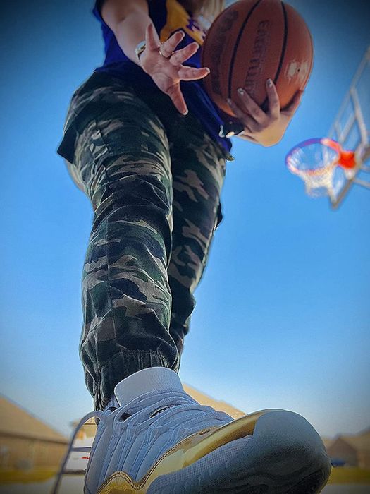 Reviewer photo from a ground-level POV wearing camo cargo pants, holding a basketball.