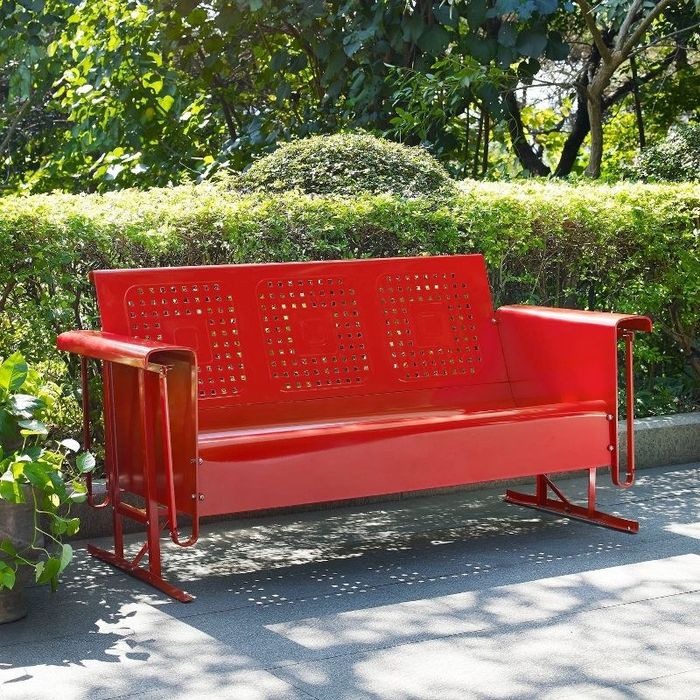 The red sofa placed outdoors, ready for some relaxation.
