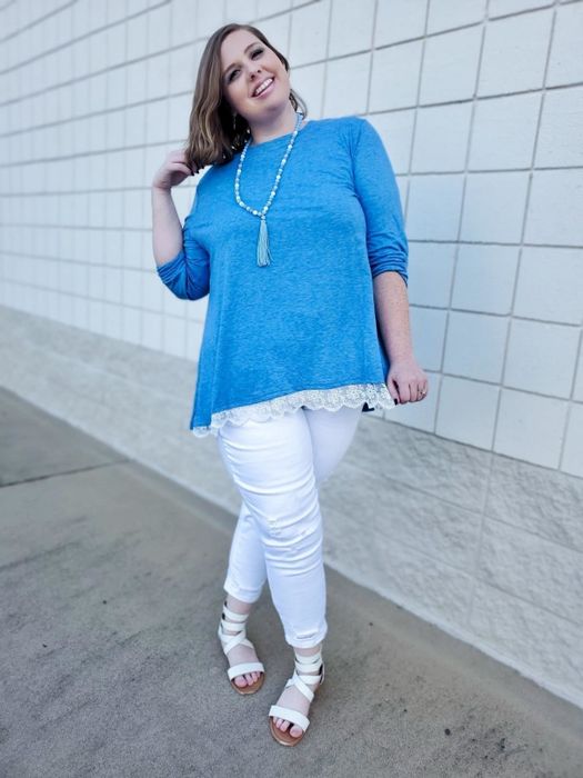 A reviewer in a blue version of the tunic with white trim