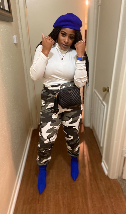A reviewer showcasing the pants in a green/gray camouflage pattern.