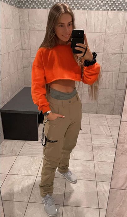Reviewer taking a mirror selfie in cargo snow pants paired with a cropped sweater