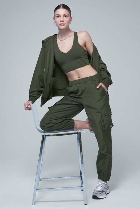 A model in green cargo pants, styled with a matching bra and jacket.