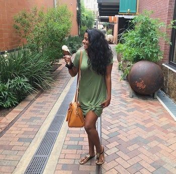 A reviewer wearing the olive green version of the item, tied at the side.