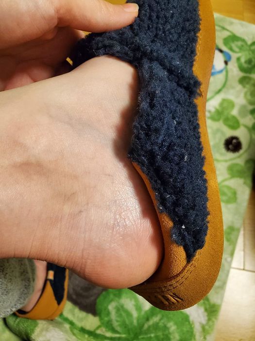 A reviewer showcases the navy version, highlighting the suede collapsible heel for added comfort and style.