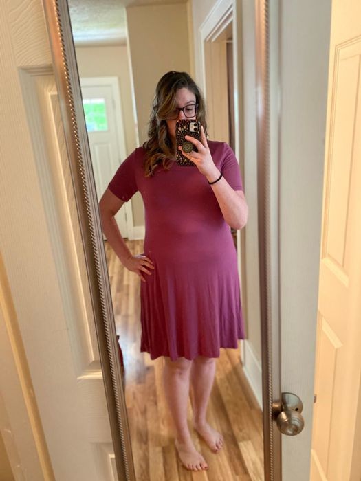 A reviewer shows off the same style dress, but in a bold red color.