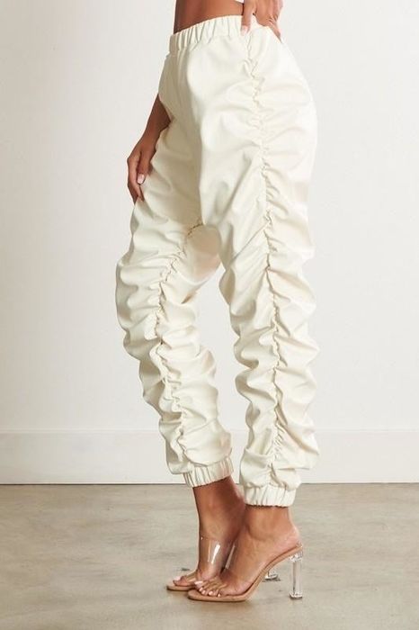 A model sporting white joggers with ruched sides