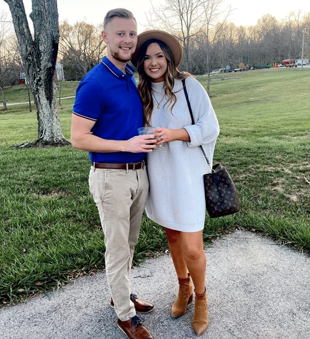 A reviewer is wearing the white sweater dress with booties.