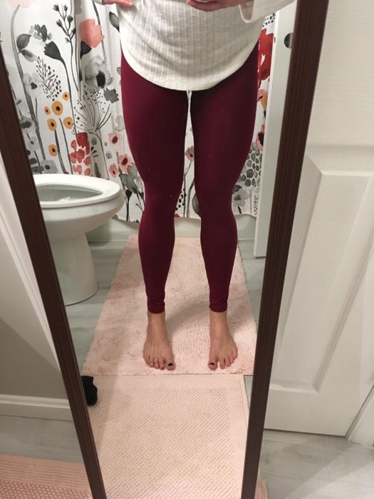 A reviewer wearing the deep maroon leggings