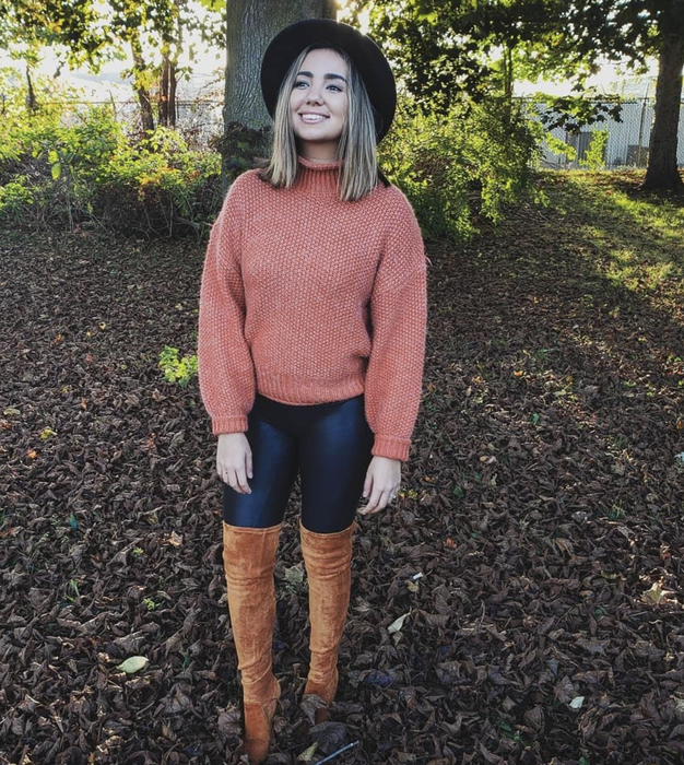 A reviewer is wearing the orange sweater.