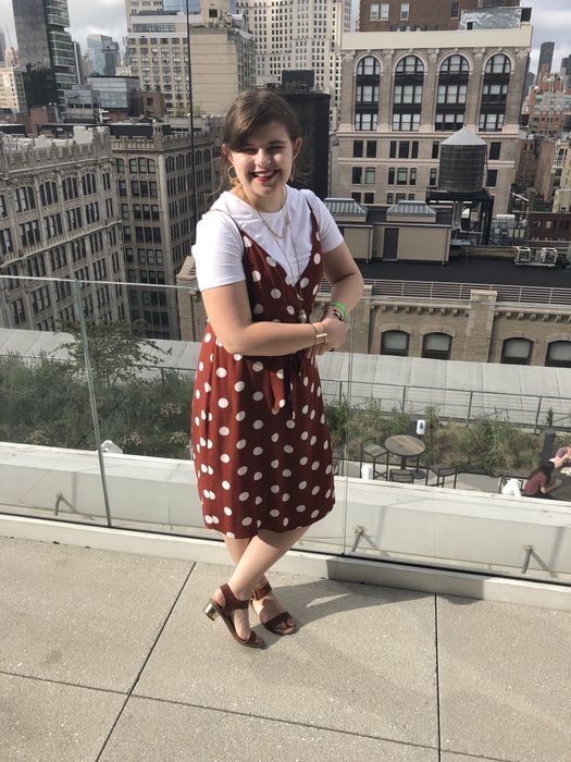 Mytour Editor styled the shirt beneath a red spaghetti strap dress adorned with white polka dots.