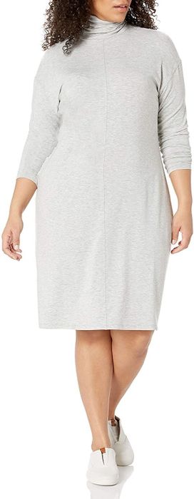 The model is wearing a gray turtleneck dress paired with white sneakers.