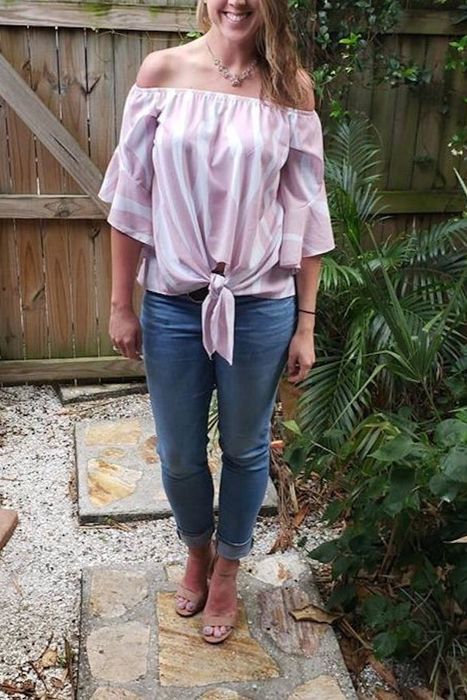Another reviewer wearing the same top in white and pink zebra stripes, paired with jeans