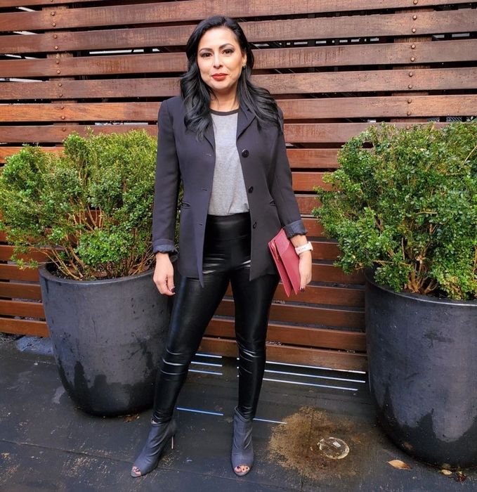 A reviewer is wearing faux leather leggings.
