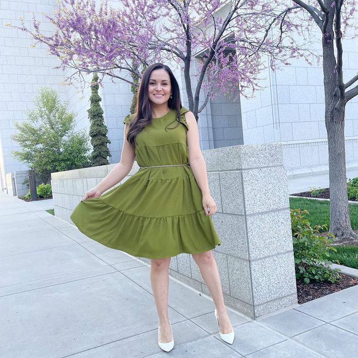 A reviewer wears the green pleated dress paired with white pointed heels for a chic yet comfortable outfit.