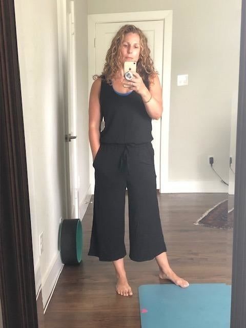 A mirror selfie showcasing a reviewer in a chic black wide-leg jumpsuit.